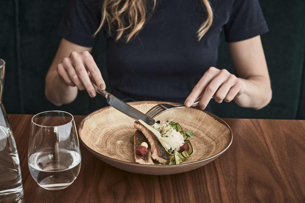 Falkensteiner Balance Resort Stegersbach - Adults Only レストラン 写真 A woman using a knife and fork to eat a salad